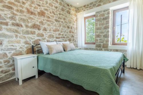 sypialnia z łóżkiem z kamienną ścianą w obiekcie Annas Horizon w mieście Samotraka