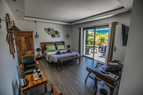 a bedroom with a bed and a sliding glass door at Les Cuves - Saintes in Chaniers