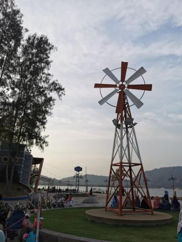 a large wooden windmill in a park with people at Lumut Titi Panjang Apartment in Lumut