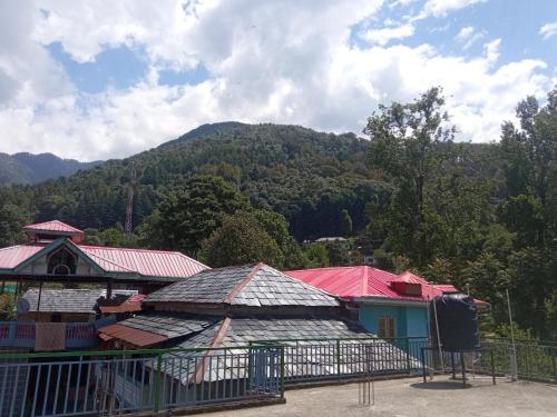 a group of buildings with a mountain in the background at Travelodge Homestay in Bīr