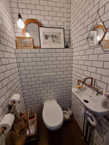 une salle de bain blanche avec des toilettes et un lavabo dans l'établissement Maison bord de mer, à Zuydcoote