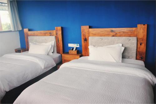 two beds in a room with blue walls at 张家界天门山伴田居民宿 in Zhangjiajie