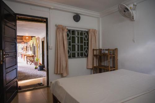 a bedroom with a bed and a door to a patio at Kep Melting Potes in Kep