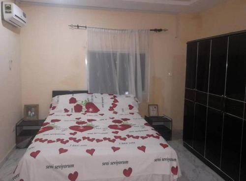 Un dormitorio con una cama con corazones rojos. en Comfy & cozy 2 bedroom apartment, entire unit!, en Banjul
