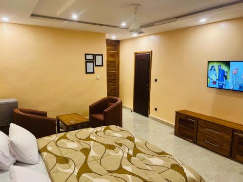 um quarto de hotel com uma cama e uma televisão em Le Baobab em Bamako