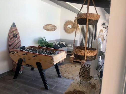 a living room with a pool table and a surfboard at Le Soustet in Malaucène