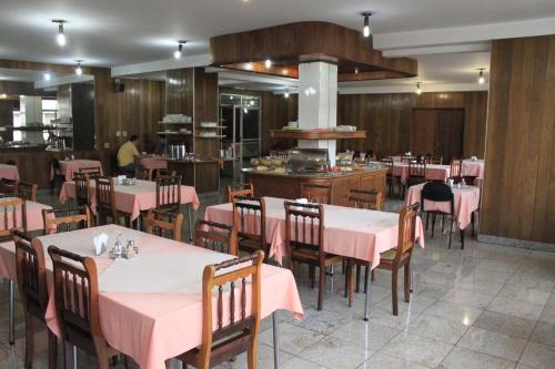 Fenícia Palace Hotel في باورو: غرفة طعام مع طاولات وكراسي وردية