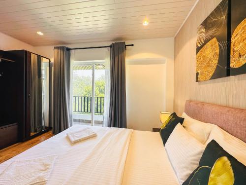 a bedroom with a large bed with a window at The Edge Luxury Apartment in Nuwara Eliya