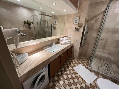 a bathroom with a sink and a shower at Apartament Bryza - Szczęśliwa Dziewiątka in Jurata