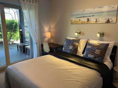 a bedroom with a bed and a door to a patio at Apartament Bryza - Szczęśliwa Dziewiątka in Jurata