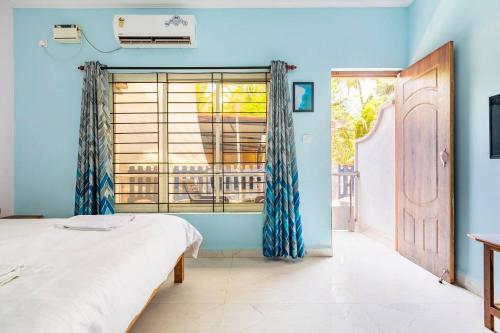 a bedroom with a bed and a window at Cerca Del Mar in Calangute