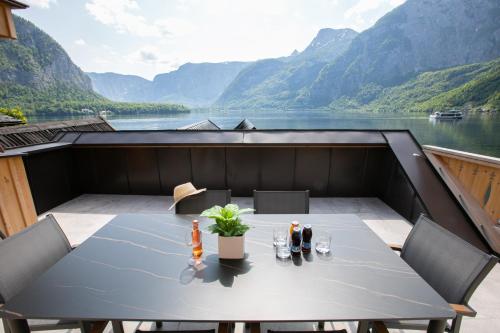 a table on a balcony with a view of a lake at Weisses Lamm in Hallstatt