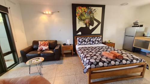 uma sala de estar com uma cama e um sofá em The Courtyard em Port Pirie