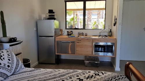 a small kitchen with a sink and a refrigerator at The Courtyard - Garden View Studio in Port Pirie