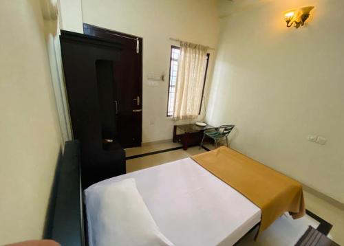 a bedroom with a white bed in a room at Rosh Tower in Trivandrum