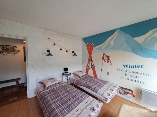 two beds in a room with a mural on the wall at L'appart de Saint-Lary in Saint-Lary-Soulan