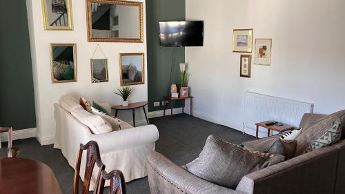 a living room with two couches and a tv at Rose Cottage - City Centre, Hospital CrownWork Studios, Nissan & Stadium of Light in Sunderland