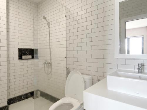 Dien Khanh的住宿－Florihome Beach House，白色的浴室设有卫生间和水槽。