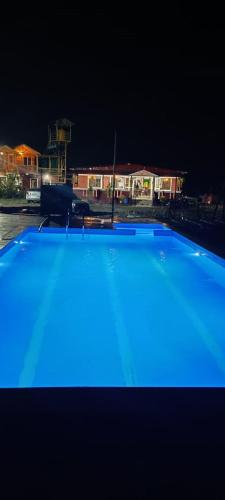 a large blue swimming pool at night at Sunrise Room, Wai in Wai
