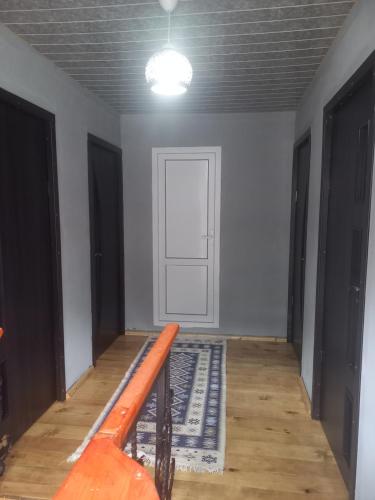 Habitación con puerta y pasillo con alfombra en Sesili Guesthouse en Adishi