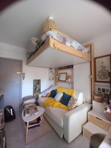 een woonkamer met een bank en een stapelbed bij Studio 300m plage in Saint-Laurent-du-Var
