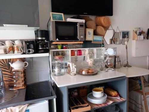 uma cozinha com um balcão com um micro-ondas e alguns alimentos em Studio 300m plage em Saint-Laurent-du-Var