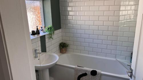 a bathroom with a white tub and a sink at Sunderland Stays, Rose, City Centre, HS Wi-Fi, Smart TV & Free Parking in Sunderland