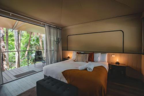 a bedroom with a large bed and a large window at Tiona Holiday Park in Tiona
