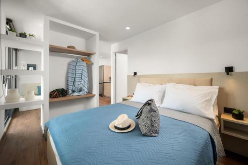 sypialnia z niebieskim łóżkiem z kapeluszem w obiekcie Nieva Apartment 2 w mieście Matala