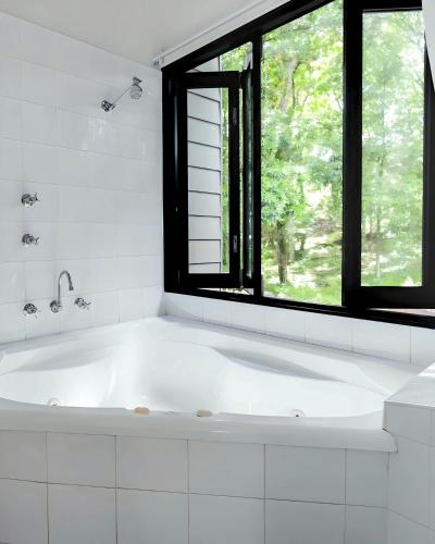a white bath tub in a bathroom with a window at Tiona Holiday Park in Tiona