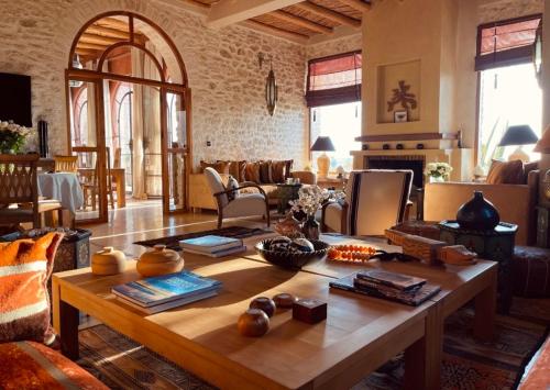 un soggiorno con tavolo in legno in una camera di Villa des Hauts Mogador a Essaouira