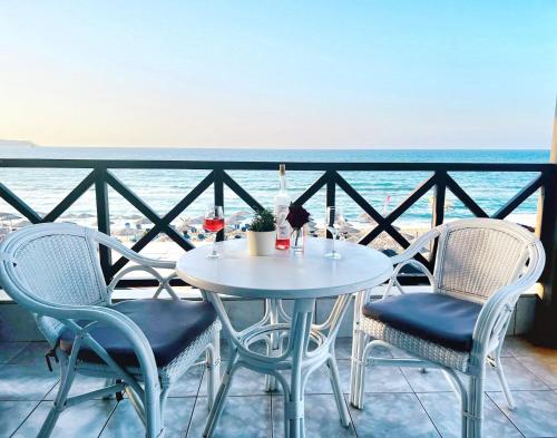 a table and chairs with a view of the ocean at Troulis Seaside in Amoudara Herakliou