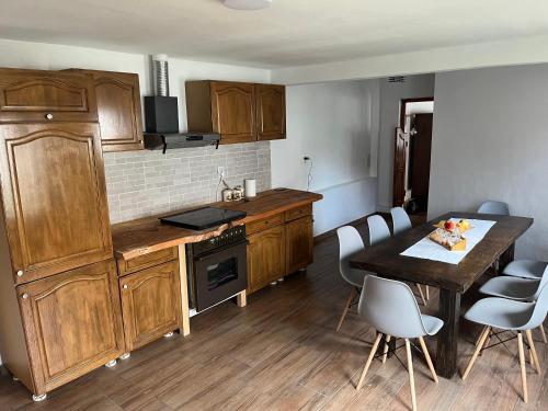 a kitchen with wooden cabinets and a table and chairs at Casa Ariana in Poiana Aiudului