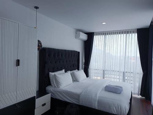 ein Schlafzimmer mit einem großen Bett mit einem großen Fenster in der Unterkunft Double R Villa F11 Dago Village in Bengkok