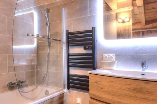 La salle de bains est pourvue d'une douche et d'un lavabo. dans l'établissement Chalet vue Mont Blanc avec jacuzzi extérieur, à Combloux