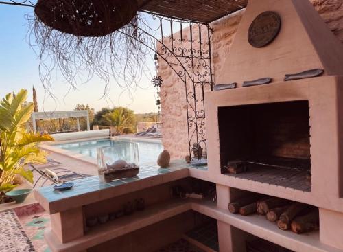 a outdoor fireplace next to a swimming pool at Villa des Hauts Mogador in Essaouira