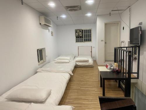a row of beds in a room with a table at 逢甲晨熙 in Taichung