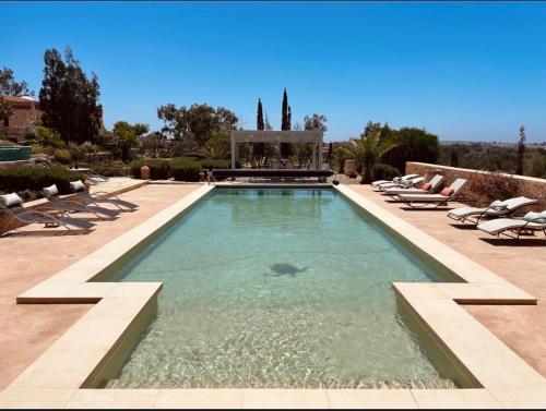 una piscina con tumbonas y una fuente en Villa des Hauts Mogador, en Essaouira