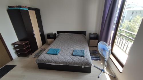 a bedroom with a bed with blue pillows and a window at U-DACHA 45 in Sunny Beach