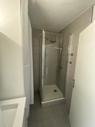 une salle de bain avec une douche avec une porte vitrée dans l'établissement Appartement à 2 min du port, à Saint-Cyprien