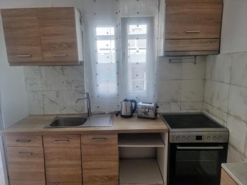 a small kitchen with a sink and a stove at Pleasure Black Beach Perissa Santorini in Perissa