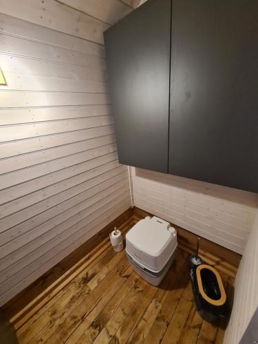 a small bathroom with a toilet and a wooden floor at Million star hotel Latgale in Nastrova