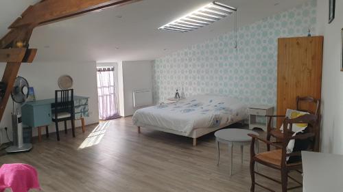 sypialnia z łóżkiem i biurkiem w pokoju w obiekcie Gite Comme a la maison w mieście Damery