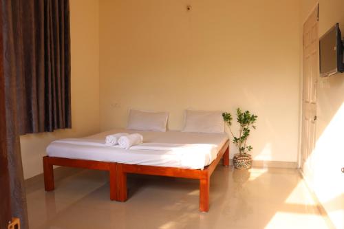 a bed with towels on it in a room at Coorg Nature Breeze Homestay in Madikeri