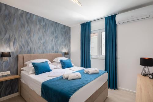 1 dormitorio con 1 cama grande y cortinas azules en A&D Deluxe apartments Dani with swimming pool, en Promajna