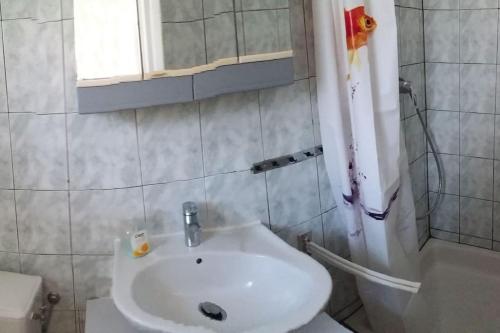 une salle de bain avec un lavabo blanc et une douche dans l'établissement T1 rez de jardin avec grande terrasse – St Aygulf, à Fréjus