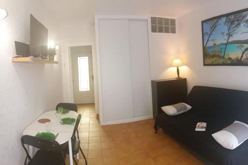 un salon avec un canapé et une table dans l'établissement T1 rez de jardin avec grande terrasse – St Aygulf, à Fréjus
