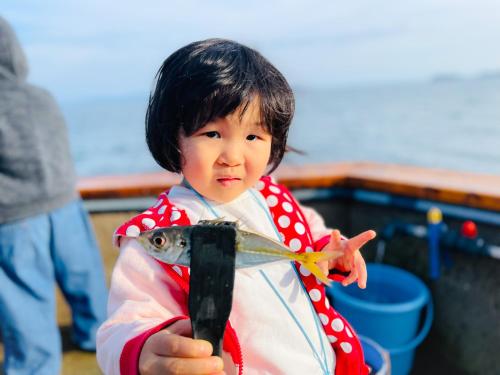 a little girl in a costume holding a fish at Awakan in Sumoto