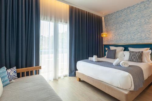 - une chambre avec un grand lit et une grande fenêtre dans l'établissement Hôtel La Piscine, au Lavandou