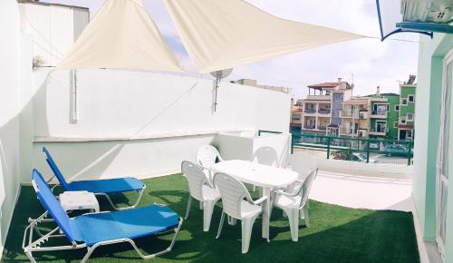 a patio with a table and chairs and an umbrella at Grace : Garden and Terrace House in Kavala